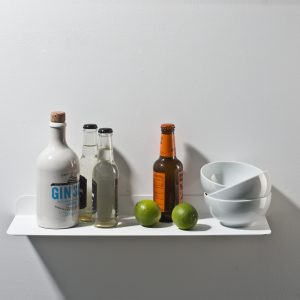 Wandregal Solid 01 von weld & co in Weiß, inszeniert als Bar im Wohnzimmer mit Gin Sul, Ginger-Bier, Limetten und weißen Schälchen.